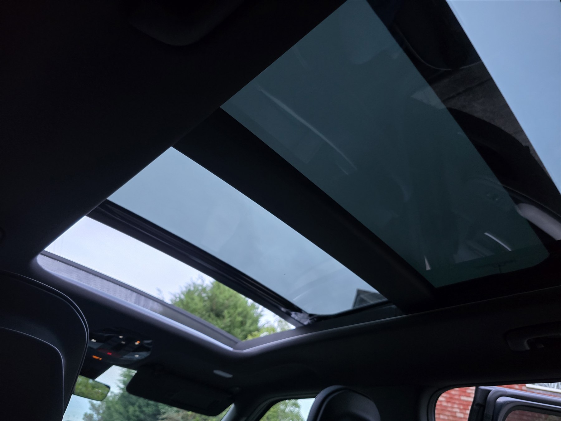 Panoramic glass roof viewed from inside a modern used car.