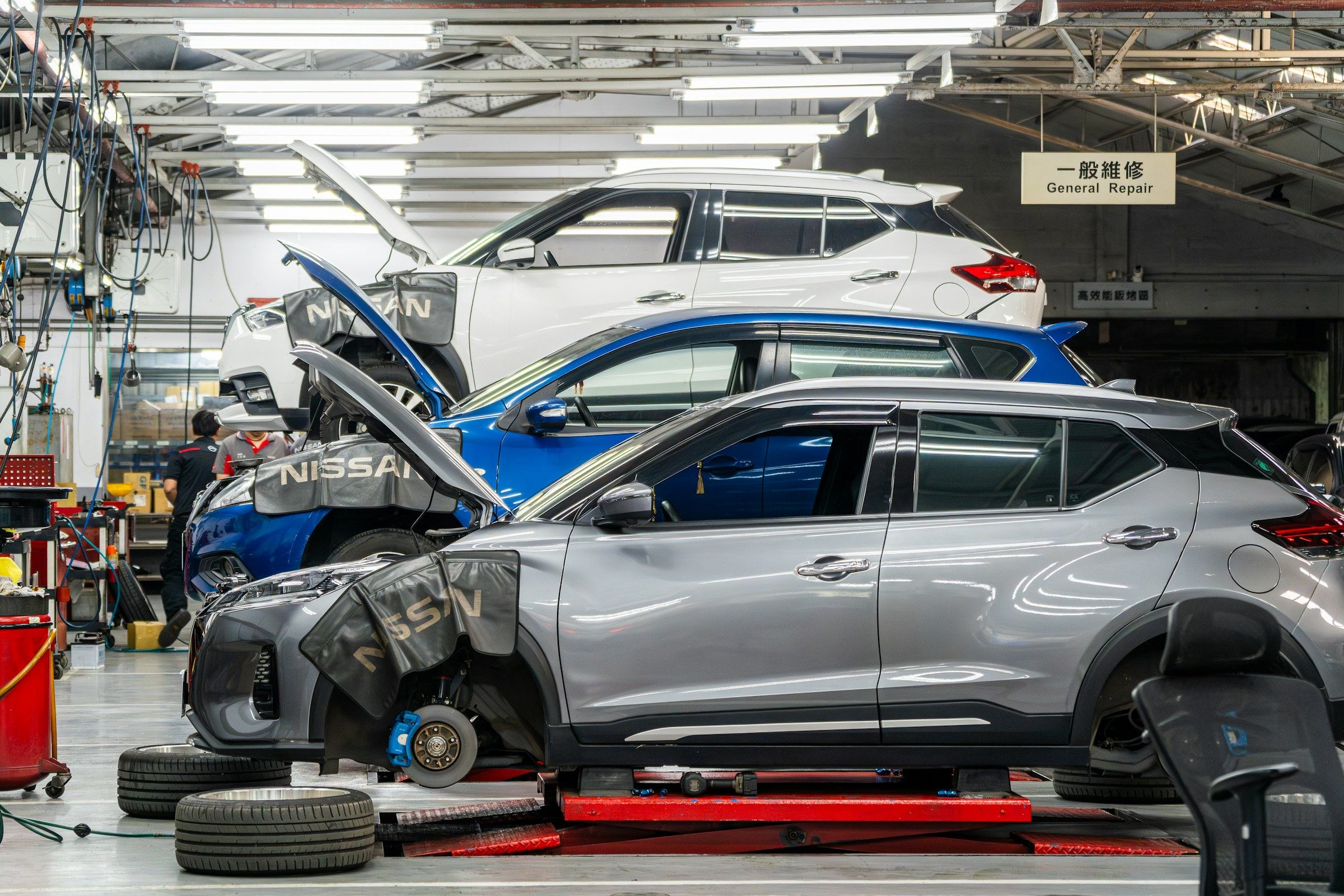 Genuine Nissan service centre with vehicles on workshop lifts