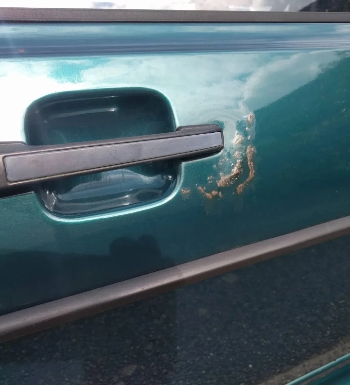 Damage around the Scirocco driver’s door handle before repair