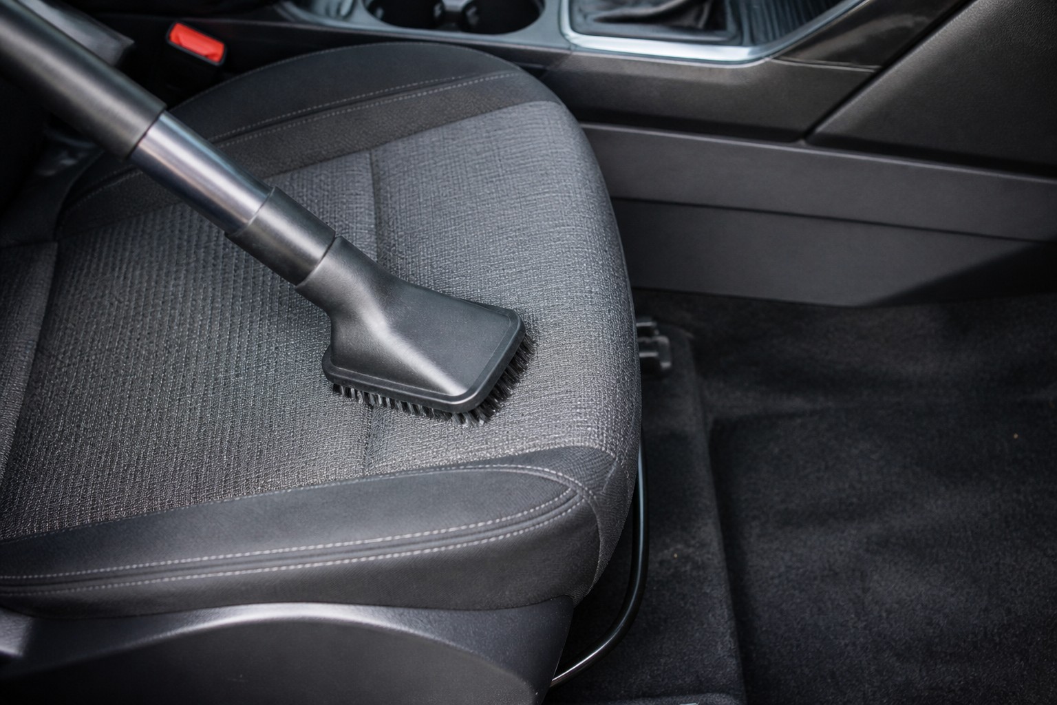 A car seat being cleaned with a proper vacuum attachment